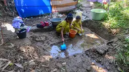 Warga mengambil air dari mata air yang bercampur lumpur di Kampung Cijaura, Desa Cidokom, Bogor, Jawa Barat, Minggu (26/07/2026). (KLY/ Arie Basuki)