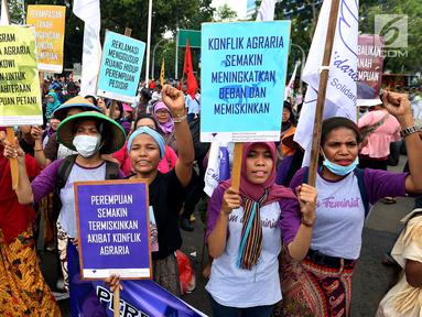 Massa tani memapangkan spanduk tuntutan dalam unjuk rasa di depan Istana Negara, Jakarta, Rabu (27/9). Memperingati Hari Tani Nasional, massa dari aliansi tani menggelar unjuk rasa menuntut reformasi agraria. (Liputan6.com/Johan Tallo)