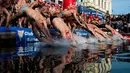 Para peserta melompat ke dalam air saat  kompetisi renang Copa Nadal di Port Vell Barcelona, Selasa (25/12). Lomba tradisional ini sudah menjadi tradisi lama yang mereka lakukan tiap tahun pada hari natal. (Josep LAGO / AFP)