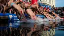 Para peserta melompat ke dalam air saat  kompetisi renang Copa Nadal di Port Vell Barcelona, Selasa (25/12). Lomba tradisional ini sudah menjadi tradisi lama yang mereka lakukan tiap tahun pada hari natal. (Josep LAGO / AFP)