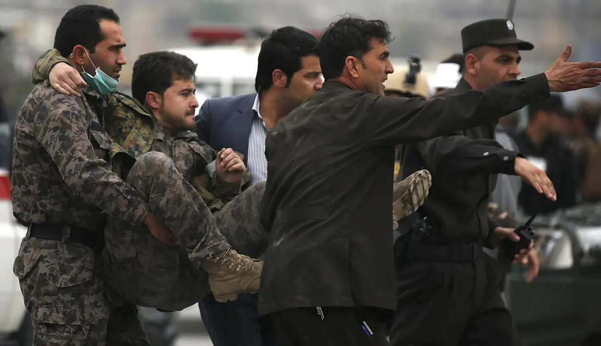 Pasukan keamanan Afghanistan membawa petugas yang terluka setelah ledakan bom bunuh diri di Kabul, Selasa (19/4). Belum ada pihak yang mengklaim soal siapa di balik serangan ini. Tetapi dugaan terkuat tertuju pada kelompok Taliban. (REUTERS/Omar Sobhani)
