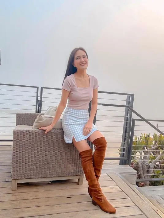 Berlibur untuk merayakan Natal dan Tahun Baru di Amerika Serikat, Shandy Aulia tampil stylish dalam balutan top square neck, slim fit skirt, dan sepatu boots. (Instagram/shandyaulia).