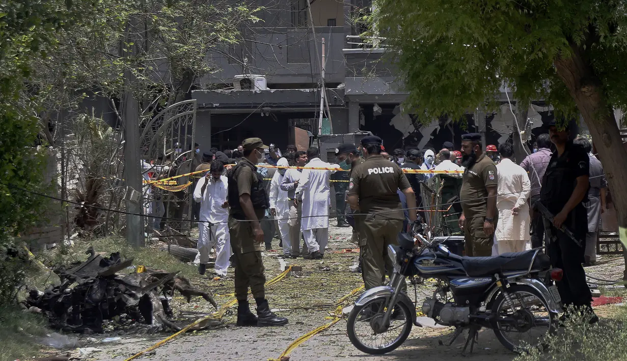 Petugas polisi, penyelidik, dan petugas penyelamat berkumpul di lokasi ledakan, di Lahore, Pakistan, Rabu (23/6/2021).  Seorang saksi mata mengatakan bahwa seorang  tak dikenal memarkir sepeda motor di dekat rumah yang kemudian meledak. (AP Photo/K.M. Chaudary)