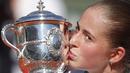  Jelena Ostapenko mencium trofi juara usai mengalahkan petenis Rumania, Simona Halep pada Final Prancis Terbuka 2017 di Roland Garros, Paris, (10/6/2017). Ostapenko menang 4-6, 6-4, 6-3. (AP/Christophe Ena)