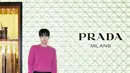 Hwang In-Youp hadir dengan tampilan memikat. Vibrant pink knit sweater yang dipadukan dengan celana hitam tas Prada leather sling bag berwarna cokelat. / Foto dok Prada.