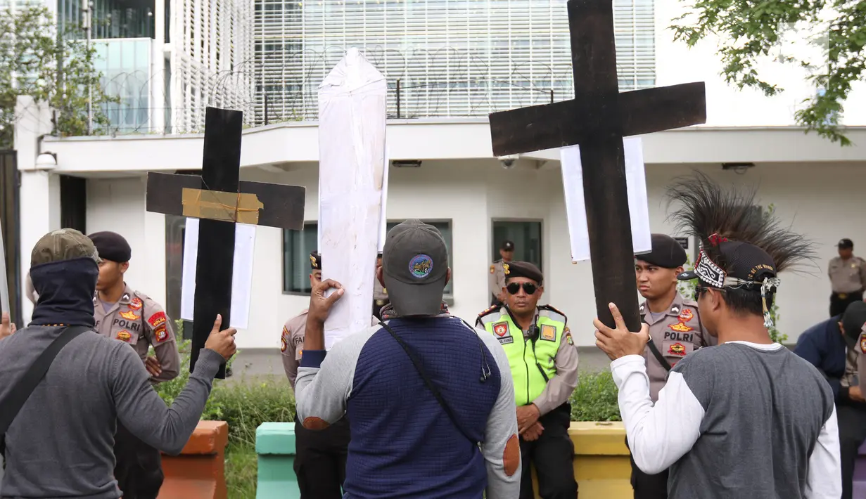 Massa membawa atribut salib dalam unjuk rasa di depan Kedubes AS, Jakarta, Kamis (27/12). Mereka menuntut Dubes AS Joseph R. Donovan Jr bertanggungjawab atas dugaan pelanggaran HAM yang dilakukan oleh PT Freeport Indonesia. (Liputan6.com/Angga Yuniar)