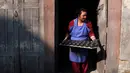 Seorang pembuat tembikar membawa lampu tanah yang dipersiapkan untuk Festival Tihar atau Yama Panchak di Bhaktapur, Nepal, 21 Oktober 2022. Selama festival lima hari yang mirip dengan Festival Diwali di India tersebut, umat Hindu mendekorasi rumah dan tempat ibadah mereka. (AP Photo/Niranjan Shrestha)