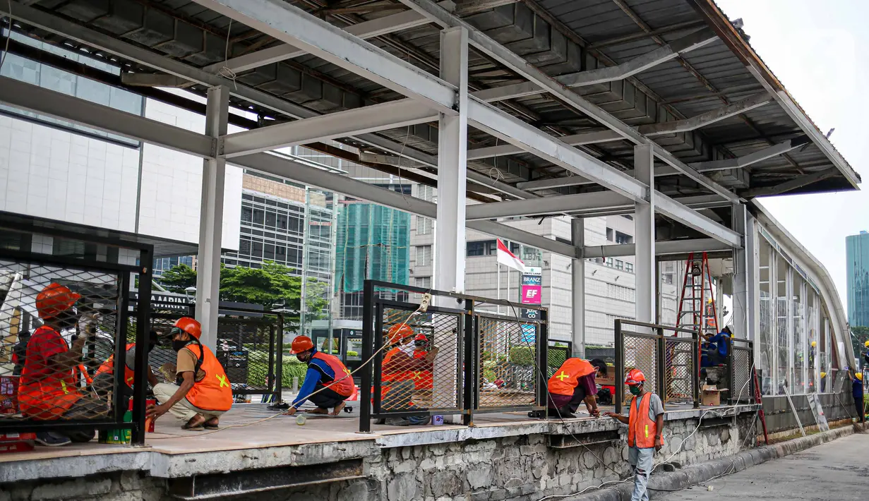 Pekerja menyelesaikan perbaikan Halte Transjakarta yang dibakar pasca aksi unjuk rasa di kawasan Bundara HI, Jakarta, Minggu (11/10/2020). Direktur Utama PT Transportasi Jakarta Sardjono Jhony Tjitrokusumo mengatakan, setidaknya ada 46 halte bus rusak. (Liputan6.com/Faizal Fanani)