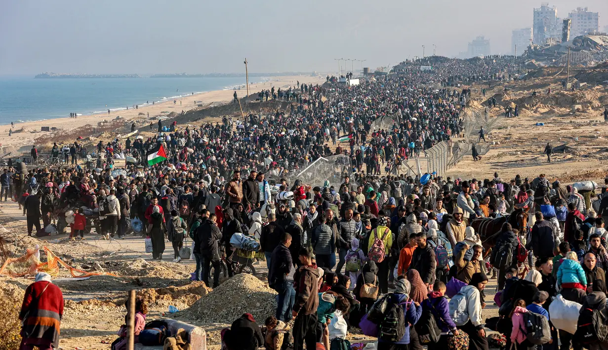 Orang-orang berjalan di sepanjang Jalan Al-Rashid di wilayah pesisir untuk menyeberangi koridor Netzarim dari Jalur Gaza selatan ke utara pada 27 Januari 2025. (Omar AL-QATTAA/AFP)