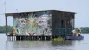 Nelayan berdiri di atas perahu dekat sebuah rumah di Cienaga Grande de Santa Marta, Nueva Venecia, Kolombia, 12 Oktober 2021. Cienaga Grande merupakan rawa terbesar di Kolombia antara Sungai Magdalena dan pegunungan Sierra Nevada de Santa Marta. (AP Photo/Fernando Vergara)