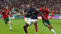 Bek Prancis, Ibrahima Konate melindungi bola dari kejaran para pemain Maroko dalam laga semifinal Piala Dunia 2022. (AP Photo/Francisco Seco)