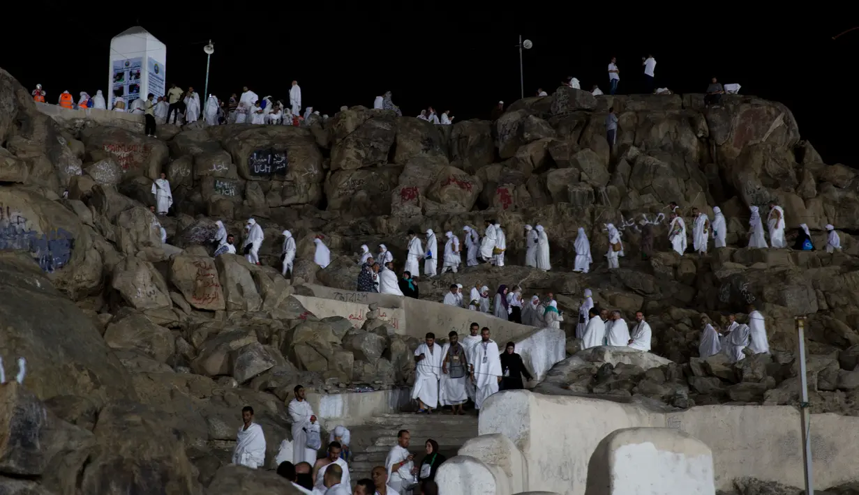 Jemaah calon haji berada di Bukit Jabal Rahmah, saat mereka tiba di Arafah untuk menjalani wukuf di luar kota suci Mekah, Arab Saudi (30/8).  Bukit Jabal Rahma dikenal sebagai bukit kasih sayang. (AP Photo / Khalil Hamra)