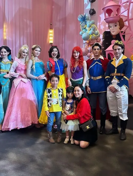 Rachel Vennya terlihat hadir mengenakan cardigan merah dan mini skirt. Tak sendirian, ia bersama sang putera, Xabiru yang berdandan ala Sheriff Woody, dan sang putri, Chava yang berdandan ala princess snow white. [@rachelvennya]