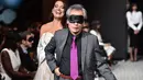 Seorang partisipan mengenakan penutup mata ketika mencoba berjalan di catwalk pada peragaan busana dengan model tunanetra selama pagelaran Paris Fashion Week di Paris, Rabu (5/10). (AFP PHOTO/Christophe Archambault)