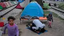 Seorang imigran melakukan ibadah di sebuah stasiun kereta api di sebuah kamp darurat bagi para migran dan pengungsi di perbatasan Yunani-Macedonia dekat desa Idomeni, Yunani, 10 Mei 2016. (REUTERS / Marko Djurica)