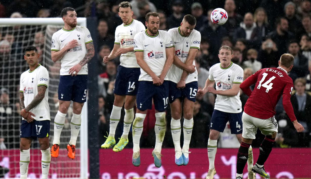 Pemain Manchester United, Christian Eriksen (kanan) melakukan tendangan bebas ke arah gawang Tottenham Hotspur pada laga pekan ke-33 Liga Inggris 2022/2023 di Tottenham Hotspur Stadium, London, Jumat (28/04/2023) WIB. Laga berakhir dengan skor 2-2. (AP Photo/Alastair Grant)