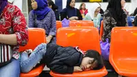 Seorang anak tertidur di kursi bersama keluarganya menunggu verifikasi data TKI dari petugas BP3TKI Serang di Bandara Soekarno Hatta, Tangerang, Sabtu (10/06). (Liputan6.com/Fery Pradolo)