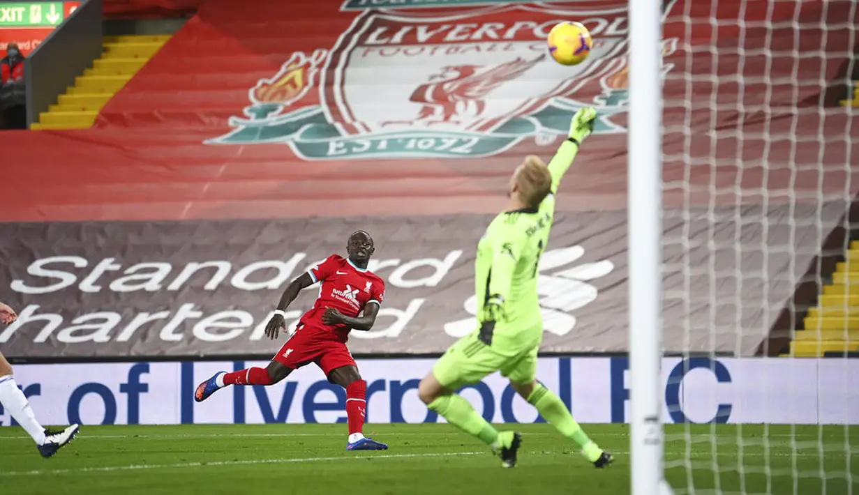 Pemain Liverpool Sadio Mane (tengah) melakukan tembakan saat penjaga gawang Leicester City Kasper Schmeichel melakukan penyelamatan pada pertandingan Liga Premier Inggris di Stadion Anfield, Liverpool, Inggris, Sabtu (22/11/2020). Liverpool menang 3-0. (Laurence Griffiths/Pool via AP)