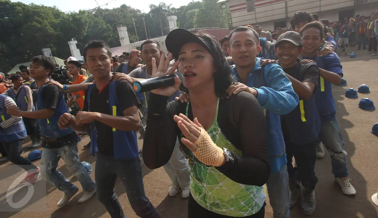 Pekerja renovasi Stadion Utama GBK mengikuti instruktur senam sebelum beraktivitas di kawasan Senayan, Jakarta, Jumat (17/3). Senam dilakukan untuk menjaga kebugaran pekerja yang rutin diadakan setiap Jumat pagi. (Liputan6.com/Immanuel Antonius)