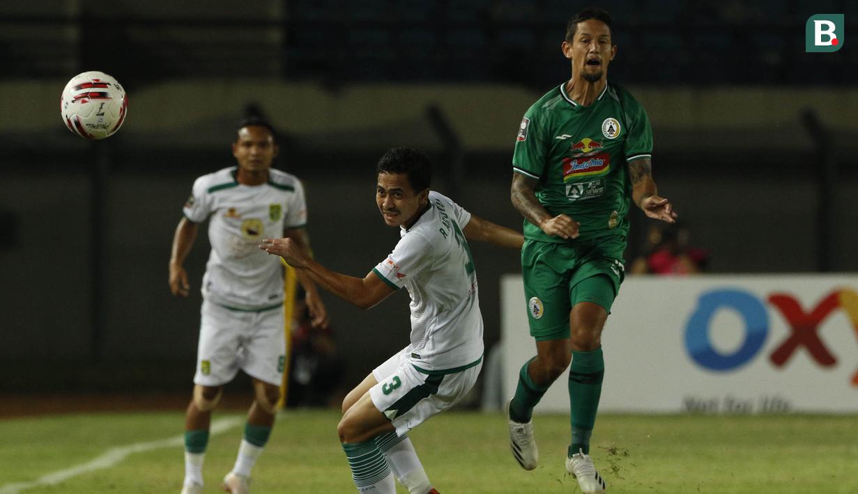 Striker PS Sleman, Irfan Bachdim (kanan) berusaha melewati bek Persebaya Surabaya, Reva Adi Utama (tengah) dalam laga Grup C Piala Menpora 2021 di Stadion Si Jalak Harupat, Bandung, Rabu (7/4/2021). (Bola.com/Ikhwan Yanuar)