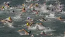 Perenang berkompetisi dalam lomba renang lintas pelabuhan di Hong Kong, Minggu (18/10). 2.500 orang ambil bagian dalam menembus jarak lintasan laut sejauh 1,5 km dari Sam Ka Tsuen Public Pier ke Quarry Bay Park Public Pier. (REUTERS/Tyrone Siu)