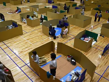 Penduduk setempat berlindung di pusat evakuasi dengan ruang untuk menjaga jarak sosial di gimnasium umum kota Yatsushiro, prefektur Kumamoto, pada 6 Juli 2020. (Charly TRIBALLEAU / AFP)