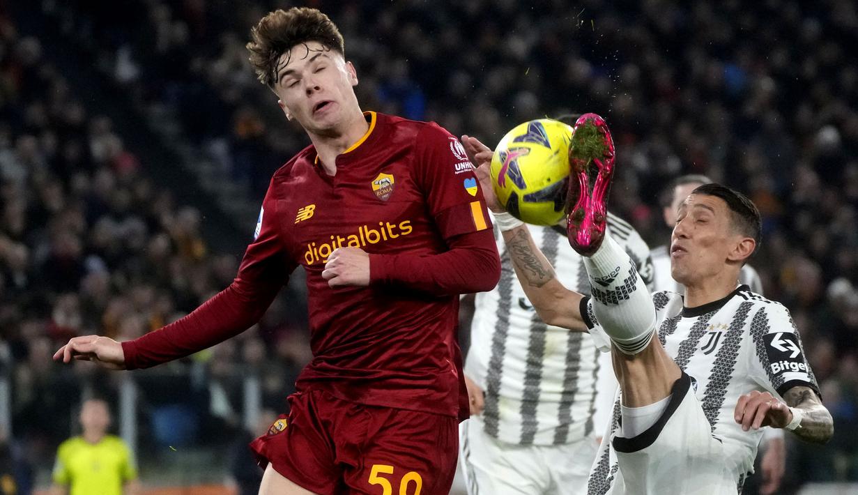 Pemain AS Roma, Nicola Zalewski (kiri) berebut bola dengan pemain Juventus, Angel Di Maria pada laga pekan ke-25 Liga Italia 2022/2023 yang berlangsung di Stadio Olimpico, Senin (06/03/2023) dini hari WIB. (AP Photo/Gregorio Borgia)