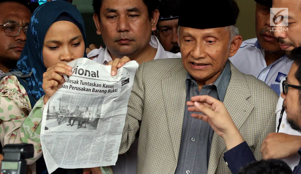 Mantan Ketua Umum DPP Partai Nasional Amanat (PAN), Amien Rais menunjukkan lembaran koran nasional saat memberikan pernyataan sebelum memasuki ruang pemeriksaan di Direktorat Kriminal Umum Polda Metro Jaya, Rabu (10/10). (Liputan6.com/Johan Tallo)