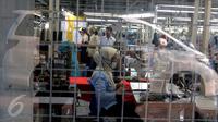 Pekerja mencoba memasangkan hasil produksi pada sebuah patung,Tangerang, Banten, Selasa (13/10/2015). Industri tekstil di dalam negeri terus menggeliat. Hal ini ditandai aliran investasi yang mencapai Rp 4 triliun (Liputan6.com/Angga Yuniar)