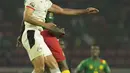 Bek Mesir, Mohamed Abdel-Moneim melompat saat berebut bola dengan penyerang Kamerun Vincent Aboubakar pada laga semifinal Piala Afrika 2021 di Paul Biya Stadium, Jumat (4/2/2022) dini hari WIB. Mesir sukses mengalahkan Kamerun 3-1 via drama adu penalti.  (AP Photo/Themba Hadebe)