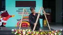Seorang petugas menyiapkan karangan bunga di kantor PSSI yang terletak di GBK Arena, Senayan, Jakarta, Kamis (30/03/2023) sebagai respon pembatalan Indonesia sebagai tuan rumah Piala Dunia U-20 2023 oleh FIFA. (Bola.com/Bagaskara Lazuardi)