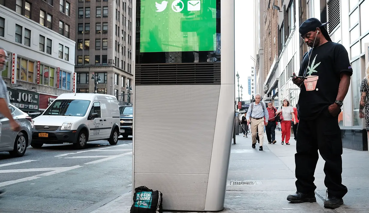 Seorang warga menggunakan salah satu kios Wi-Fi gratis di Manhattan, New York, 24 Agustus 2016. Proyek LinkNYC ini menyulap sejumlah telepon umum usang menjadi kios Wi-Fi gratis untuk bisa mengakses internet, menelepon dan pengisian baterai ponsel. (AFP)