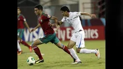 Pemain Timnas Maroko U-17, Sofyan Amrabat (kiri), mengontrol bola dibayangi pemain Uzbekistan U-17, Khumoyun Agzamov, dalam pertandingan Piala Dunia U-17 2013 yang berlangsung di Uni Emirat Arab, Senin (21/10/2013). Sofyan Amrabat bersama Timnas Maroko U-17 berhasil memuncaki Grup C Piala Dunia U-17 2013. (AFP/Karim Sahib)