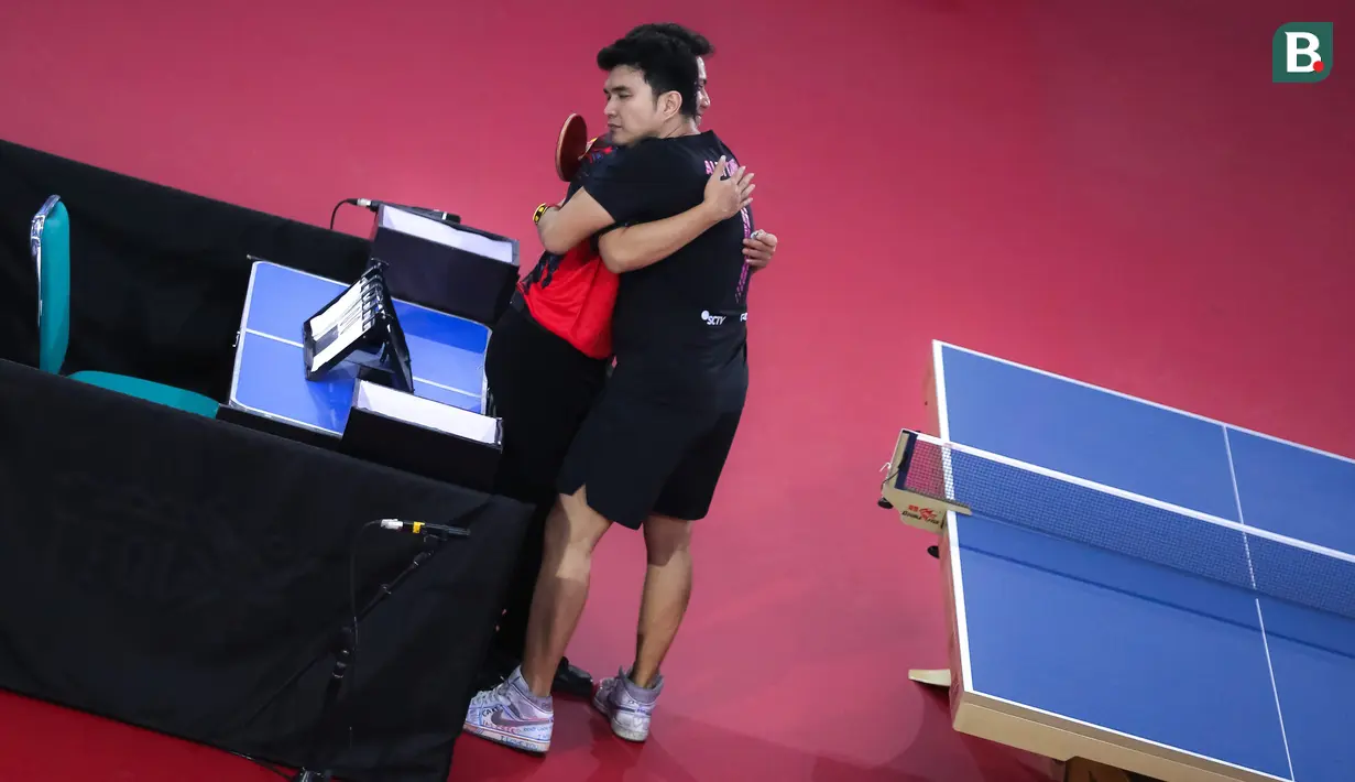 Selebritas Aldi Taher memeluk wasit sebelum laga tenis meja Turnamen Olahraga Selebriti Indonesia (TOSI) melawan Rizky Billar di GOR UNJ, Jakarta, Minggu (16/07/2023). Aldi Taher kalah tiga set langsung dari Rizky Billar dengan skor 12-21, 15-21, 11-21. (Bola.com/Bagaskara Lazuardi)