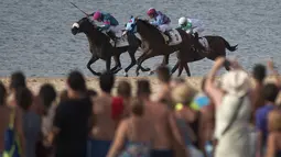 Jocky memacu kudanya dipinggir pantai pada ajang Annual Beach Horse Race di Sanlucar de Barrameda, Cadiz, (27/8/2016). (AFP/Jorge Guerrero)