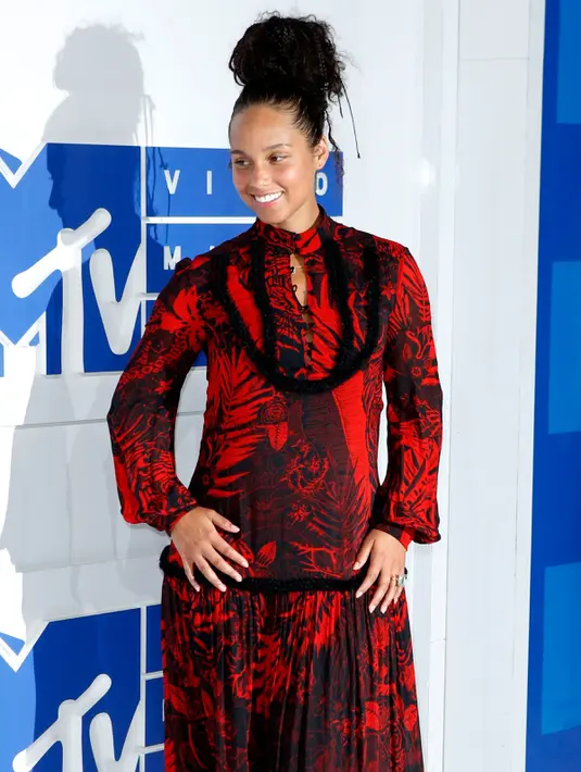 Senyum Alicia Keys ketika berpose di karpet merah ajang MTV Video Music Awards 2016 di New York, Minggu (28/8). Alicia tampil dengan gaun panjang merah-hitam motif floral, serta tatanan rambut kepang yang dikuncir tinggi.  (REUTERS/Eduardo Munoz)