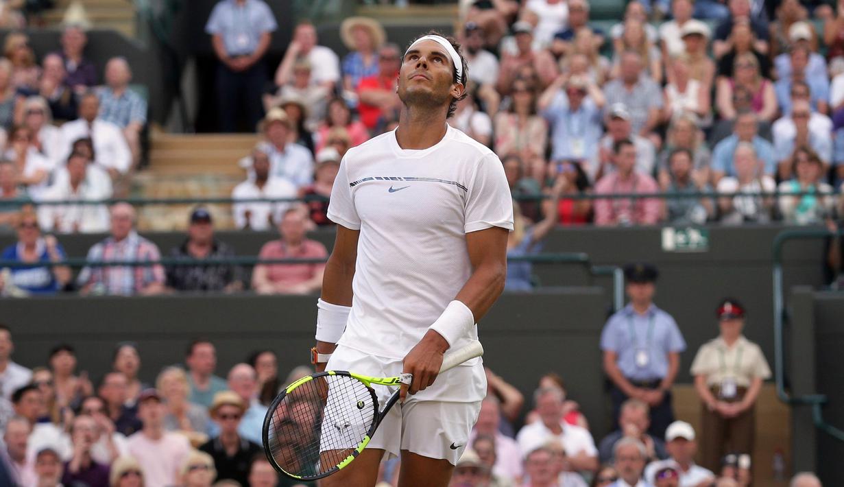 Petenis Spanyol, Rafael Nadal menengadahkan kepalanya saat melawan petenis asal Luksemburg, Giller Muller pada perempat final Wimbledon 2017 di London, Senin (10/7). Nadal akhirnya kalah dengan skor akhir 3-6, 4-6, 6-3, 6-4, 13-15. (AP/Tim Ireland)