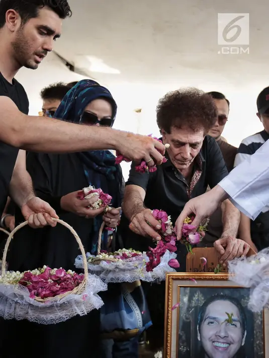 Ahmad Albar bersama putra kedua Fachri Albar menaburkan bunga ke makam almarhum Faldy Albar di TPU Tanah Kusir, Jakarta, Kamis (30/8). Diketahui, Faldy Albar meninggal pada usia 36 tahun di Rumah Sakit Abdi Waluyo. (Liputan6.com/Faizal Fanani)