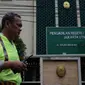 Seorang anggota kepolisian berjaga di depan PN Jakarta Utara, Senin (12/12). Ada dua mobil patroli polisi di depan gedung jelang sidang perdana Basuki Tjahaja Purnama (Ahok), namun belum ada penjagaan mencolok di lokasi.  (Liputan6.com/Johan Tallo)