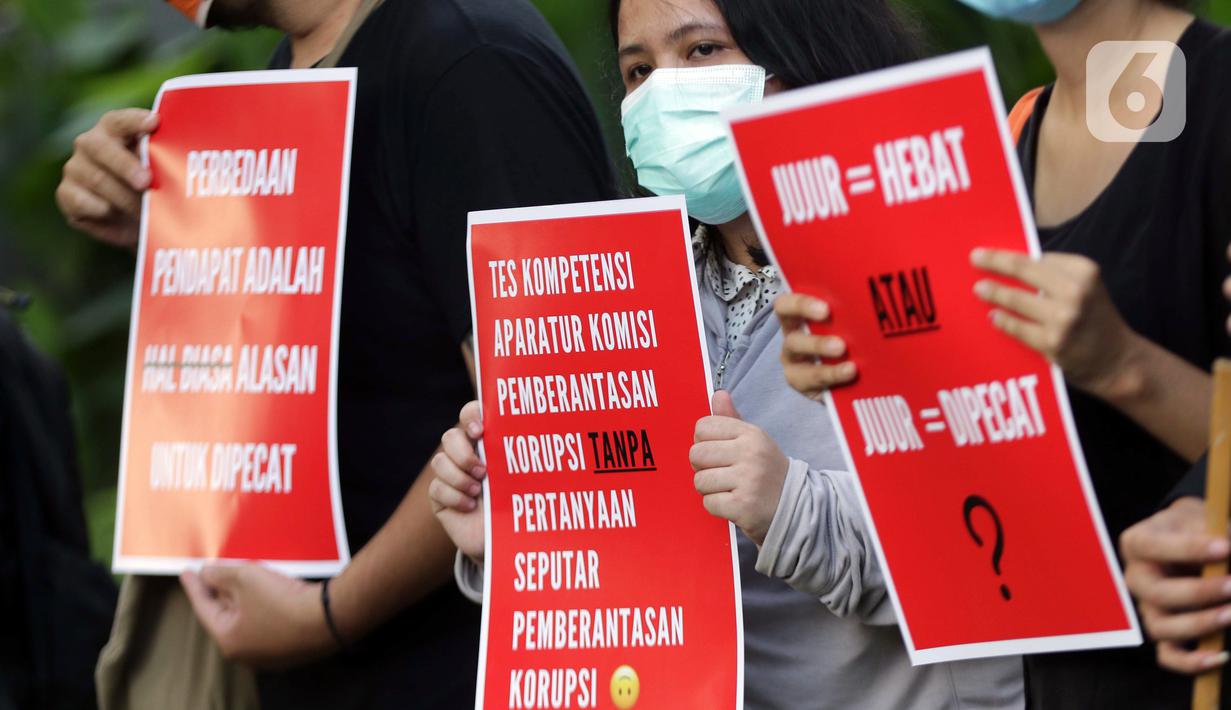 Peserta aksi dari Koalisi Masyarakat Sipil AntiKorupsi membawa poster saat berunjukrasa di depan Gedung KPK Jakarta, Selasa (18/5/2021). Dalam aksinya mereka memberi dukungan kepada 75 pegawai KPK yang dinyatakan tidak lulus TWK dalam tahap alih status kepegawaian. (Liputan6.com/Helmi Fithriansyah)