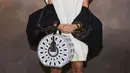 Natasha Poonawalla juga tak menawan dalam balutan busana yang edgy. Ia mengenakan dress putih selutut dengan jaket parasut yang unik, menenteng hand bag berbentuk bundar, dan high shoes bertali. Foto: Document/Louis Vuitton.