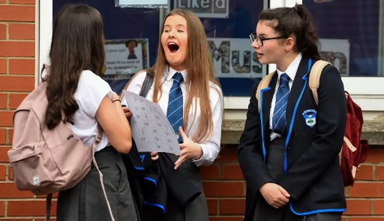 Antusiasme para pelajar Holyrood Secondary School saat kembali masuk sekolah di tengah pelonggaran lockdown di Glasgow, Skotlandia (12/8/2020).  (AFP/ANDY BUCHANAN)