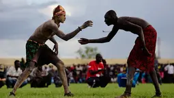 Dua pegulat bertarung sengit dalam Kompetisi Gulat Nasional Sudan Selatan di Stadion Juba, Sudan (20/4). Kompetisi ini diikuti oleh sejumlah atlet dari berbagai daerah di Sudan. (CARL DE SOUZA / AFP)