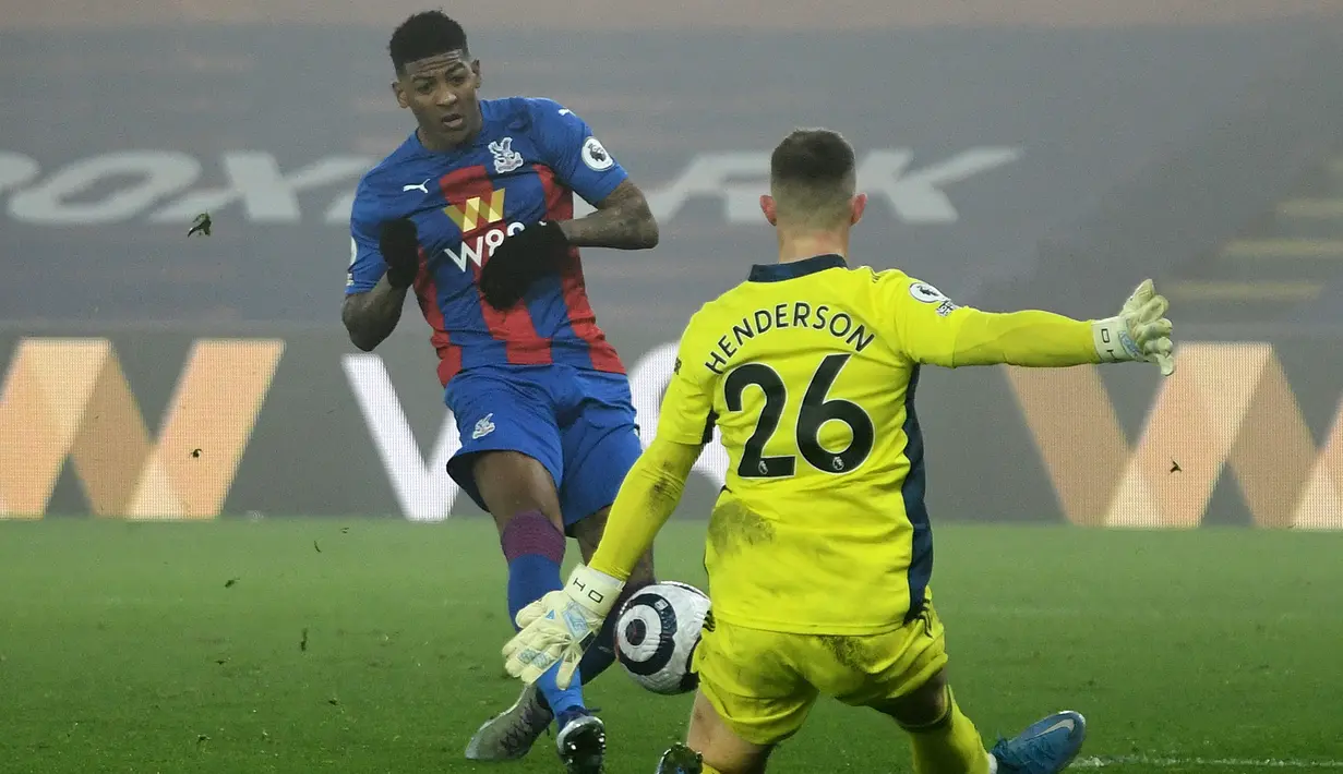Bek Crystal Palace, Patrick van Aanholt melepakan tendangan yang berhasil dipatahkan kiper Manchester United, Dean Henderson dalam laga lanjutan Liga Inggris 2020/21 pekan ke-27 di Selhurst Park, Rabu (3/3/202). Crystal Palace bermain imbang 0-0 dengan Manchester United. (AFP/Mike Hewitt/Pool)