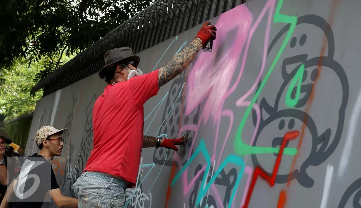 Seniman grafiti menyelesaikan karyanya selama festival Off The Wall di Kawasan Thamrin, Jakarta, Minggu (6/11). Acara ini memberikan perspektif baru terhadap seni urban sekaligus memperkenalkan para seniman Grafitti. (Liputan6.com/Gempur M. Surya)