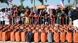 Sejumlah orang mengatarkan keluarga mereka bertolak ke Tanah Suci Mekah di Bandara Provinsi Narathiwat, Thailand, Kamis (4/7/2019). Jutaan umat muslim dari penjuru dunia akan bertolak menuju Mekah untuk melangsungkan ibadah haji. (Madaree TOHLALA/AFP)