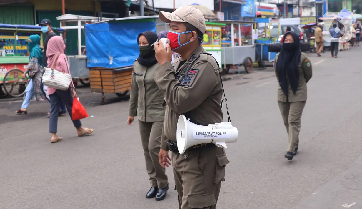 Petugas Satpol PP mengimbau warga untuk menggunakan masker dan menjaga jarak di Pasar Lama, Kota Tangerang, Banten, Sabtu (9/6/2020). Pemkot Tangerang melakukan penegasan pada PSBB tahap dua dengan menugaskan petugas di keramaian guna memutus rantai penyebaran COVID-19.  (Liputan6.com/Angga Yuniar)