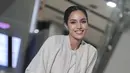 Gaya airport-nya tampak begitu santai namun sophisticated dengan paduan putih dan off white.  [foto: Suchata Chuangsri]