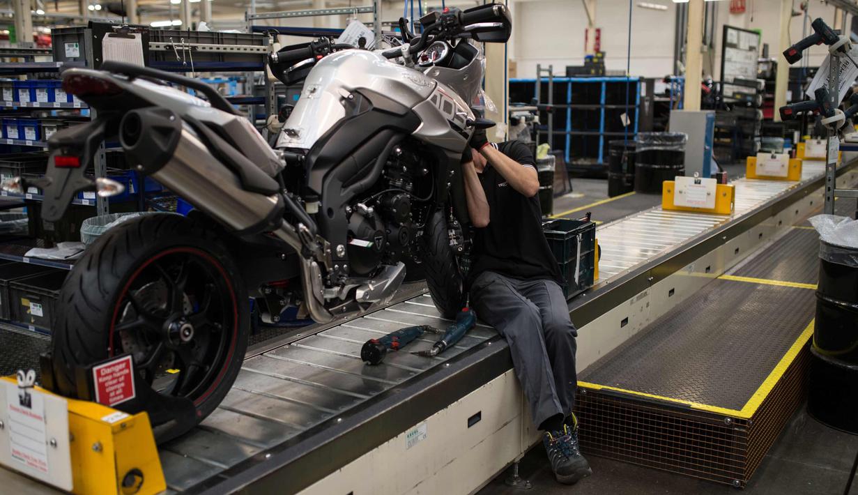 Pekerja  merakit sepeda motor Triumph di jalur perakitan di pabrik Triumph Motorcycles di Hinckley, Inggris (2/10). Awalnya Triumph dibentuk sebagai perusahaan manufaktur sepeda di Coventry pada tahun 1887. (AFP Photo/Oli Scarff)