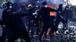 Sejumlah demonstran melempari polisi dengan batu saat aksi unjuk rasa antipemerintah di luar kantor Perdana Menteri di Tirana, Albania, Sabtu (17/10/2026). (AP Photo/Hameraldi Agolli)